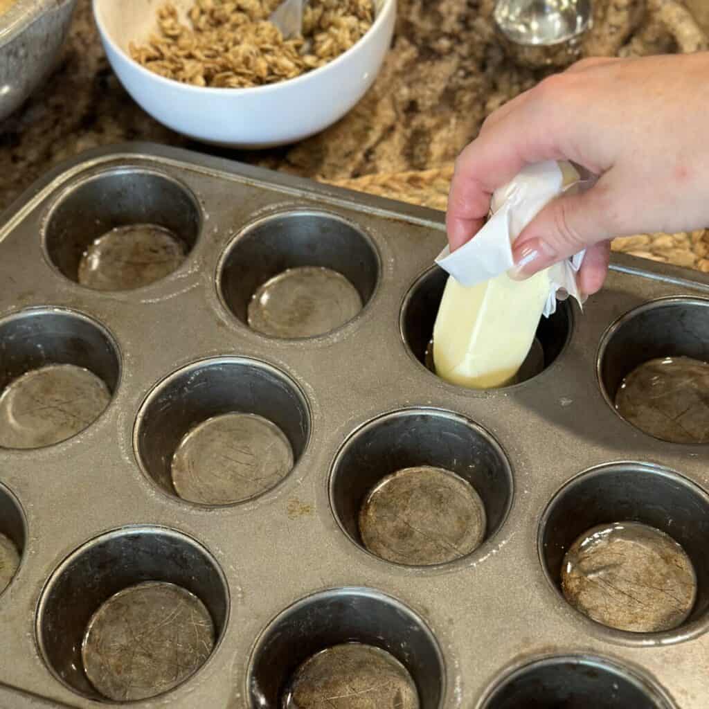 Buttering a muffin tin.
