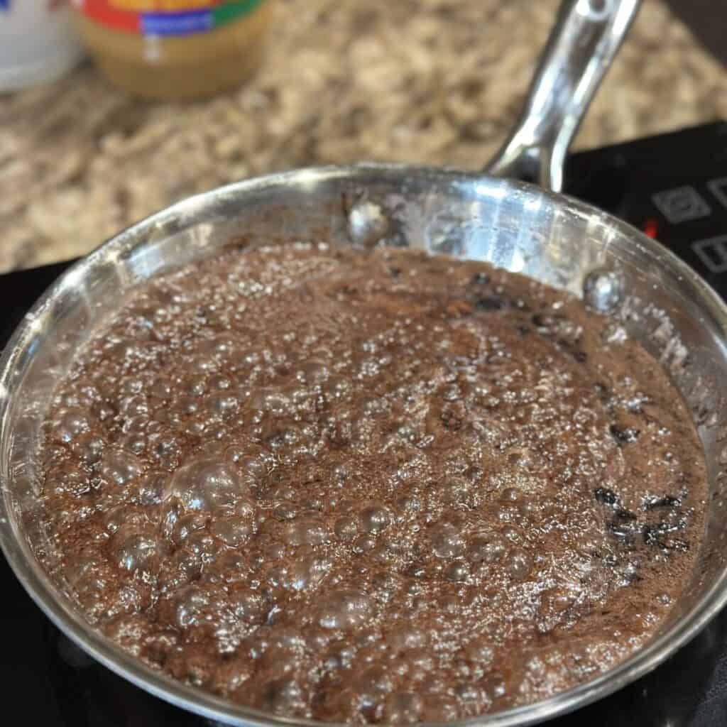 Boiling chocolate mixture for cookies in a skillet.