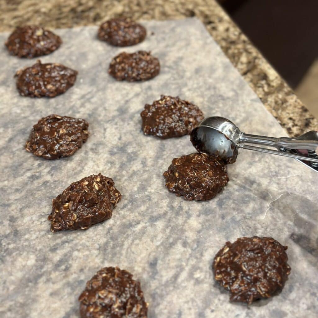 Scooping out chocolate cookies on wax paper.
