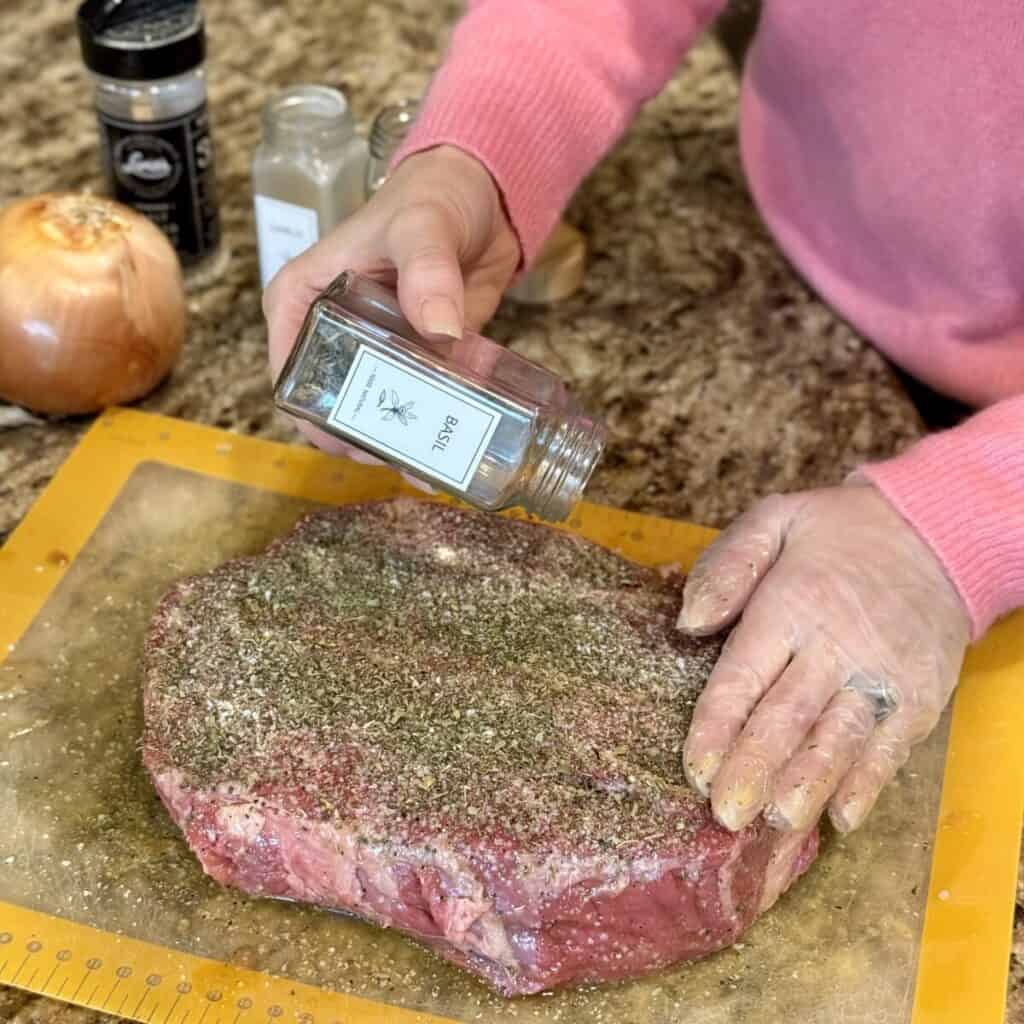 Seasoning a roast on a cutting board.