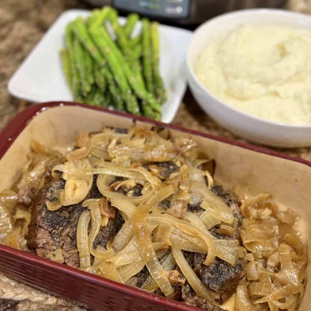 Roast beef and onions on a serving dish.