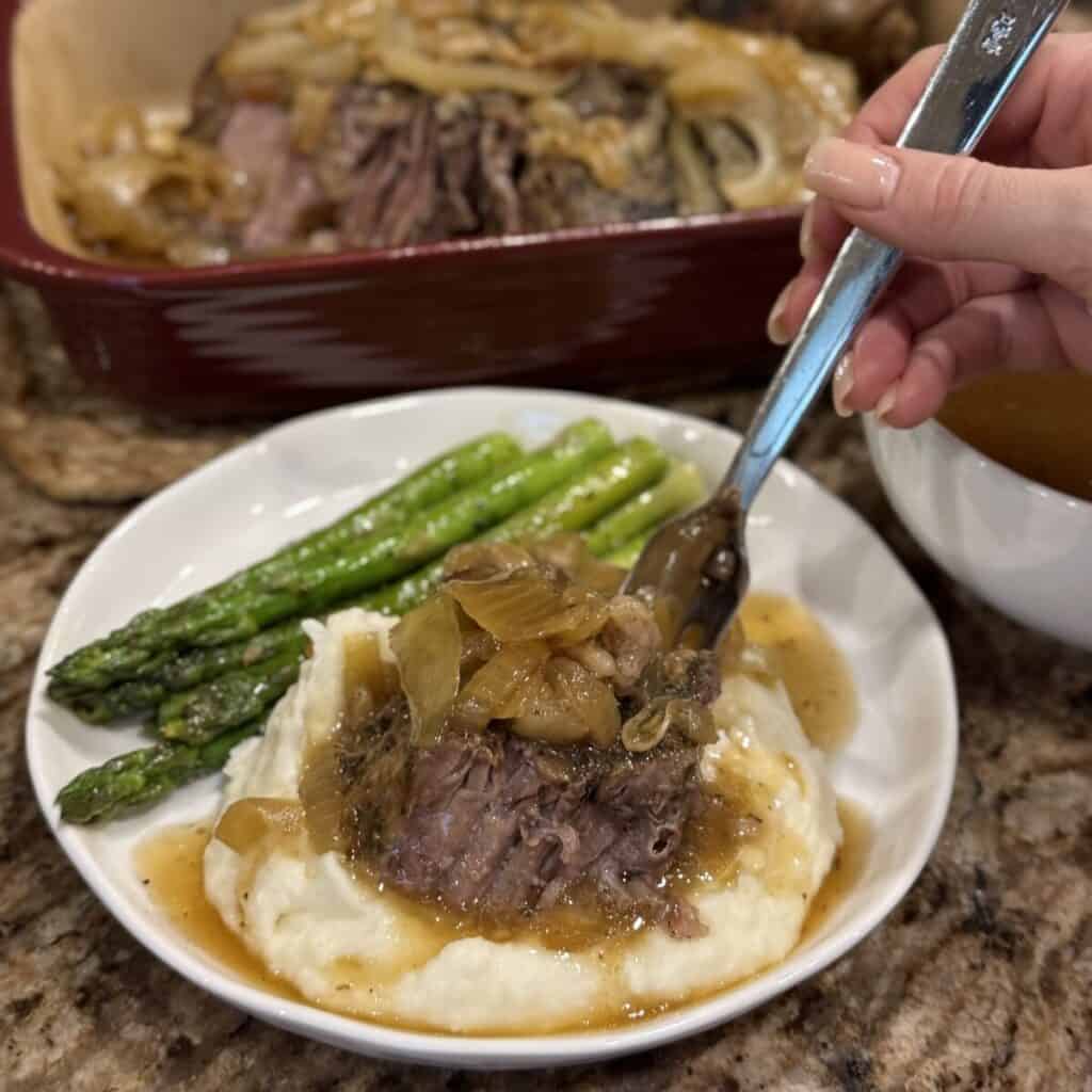 Roast beef, mashed potatoes and asparagus on a plate.