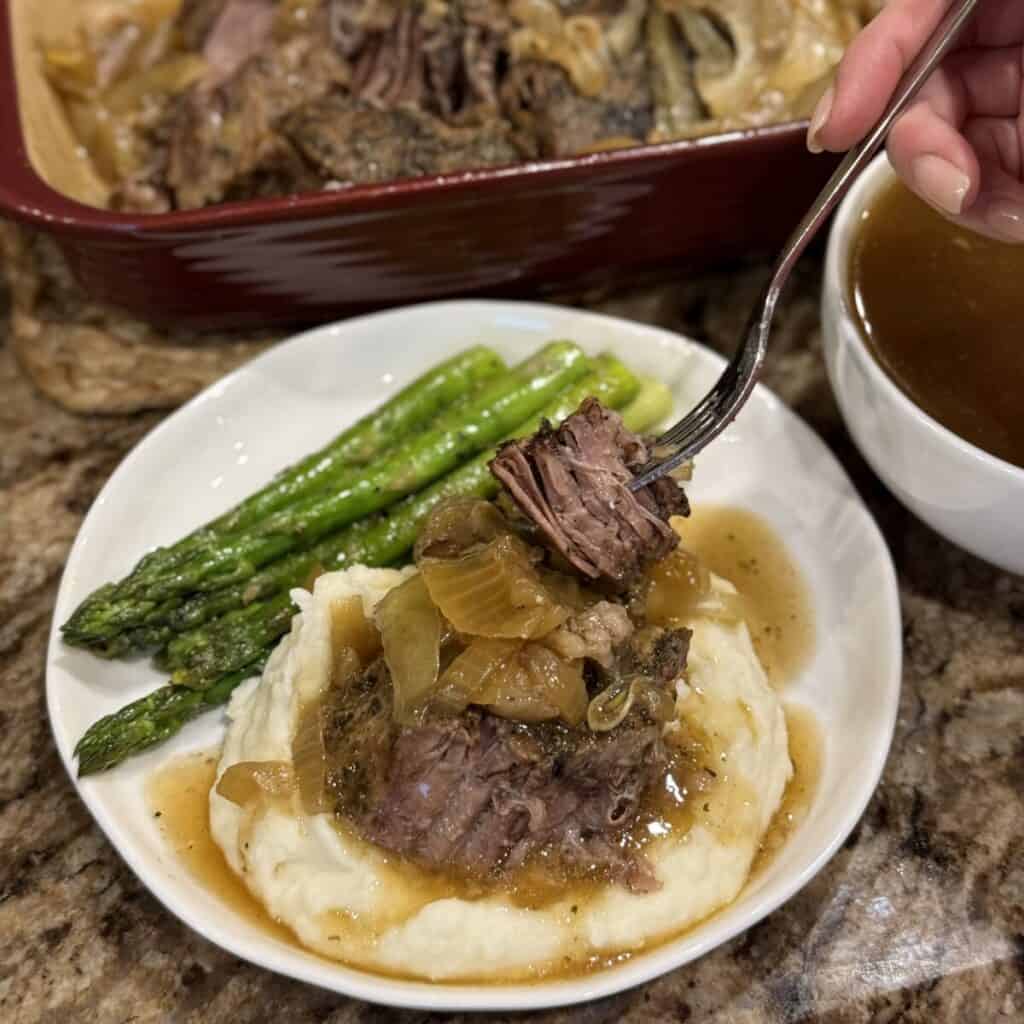 Roast beef, mashed potatoes and asparagus on a plate.