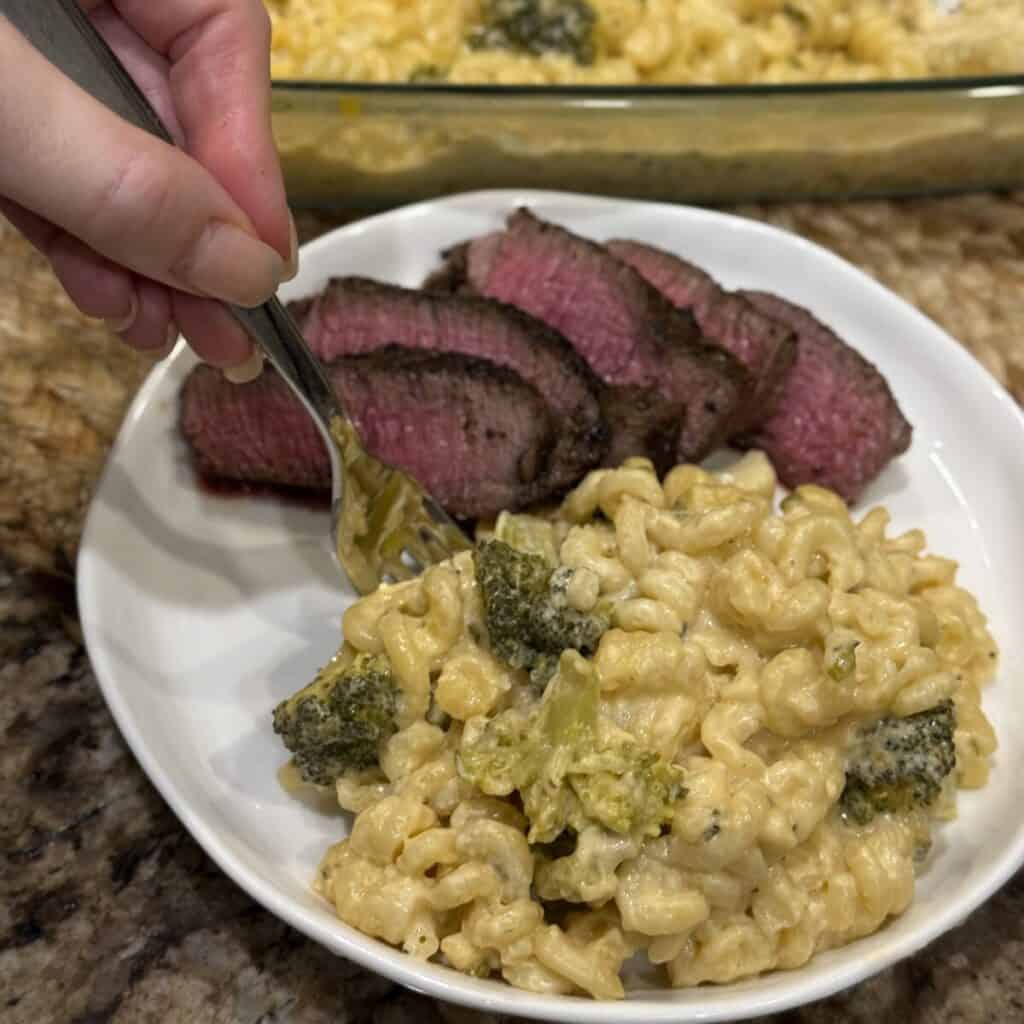 A plate of broccoli pasta bake and steak.