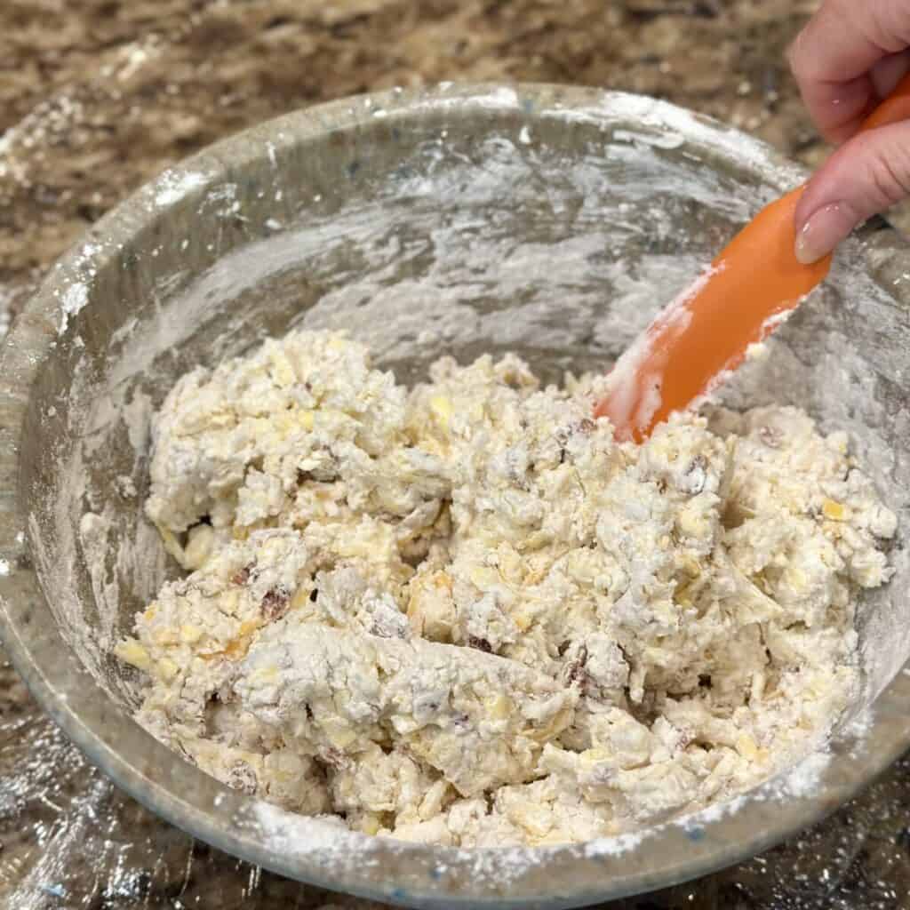 Mixing together dough for biscuits in a bowl.