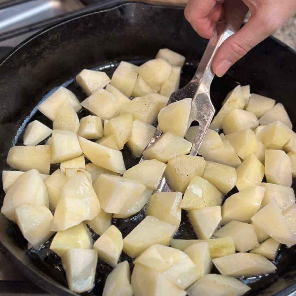 Searing potatoes in a skillet.