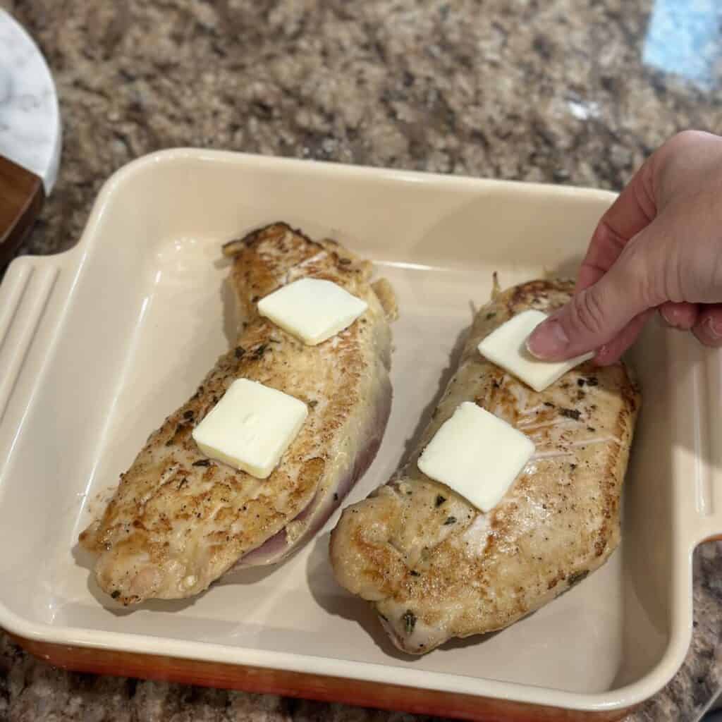 Adding butter to the top of turkey tenderloins.