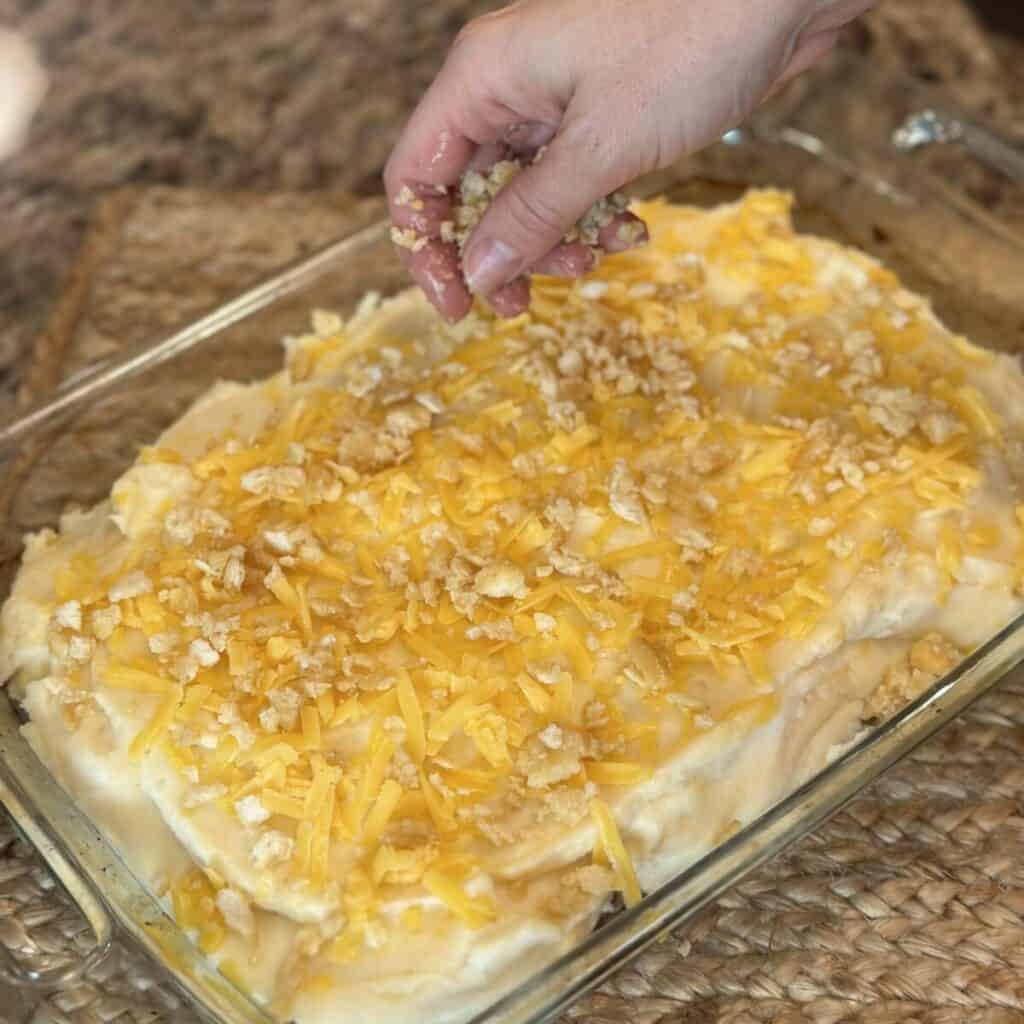 Adding crackers to the top of a meatloaf casserole.