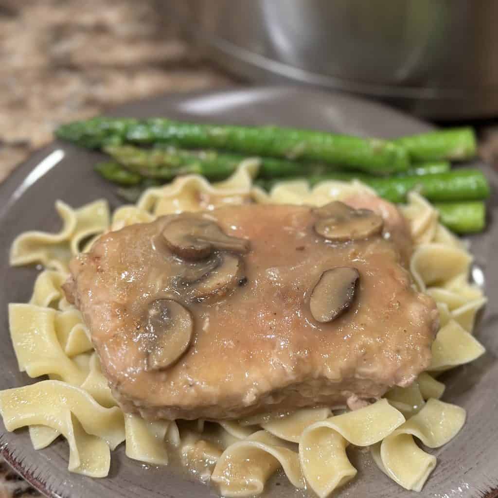 Pork chop and mushrooms on noodles. 