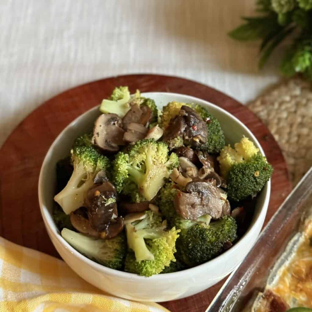 A bowl of sautéed broccoli and mushrooms.