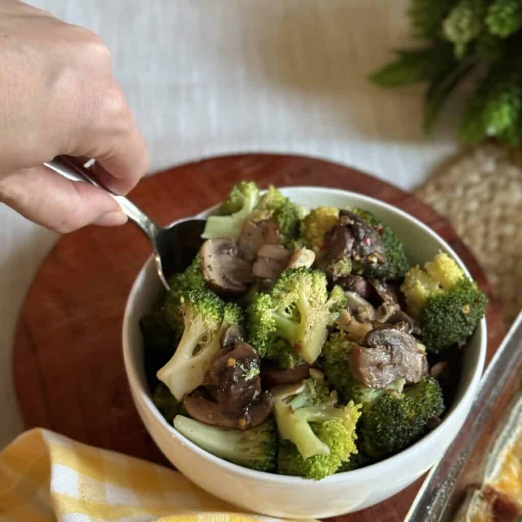 A bowl of sautéed broccoli and mushrooms.