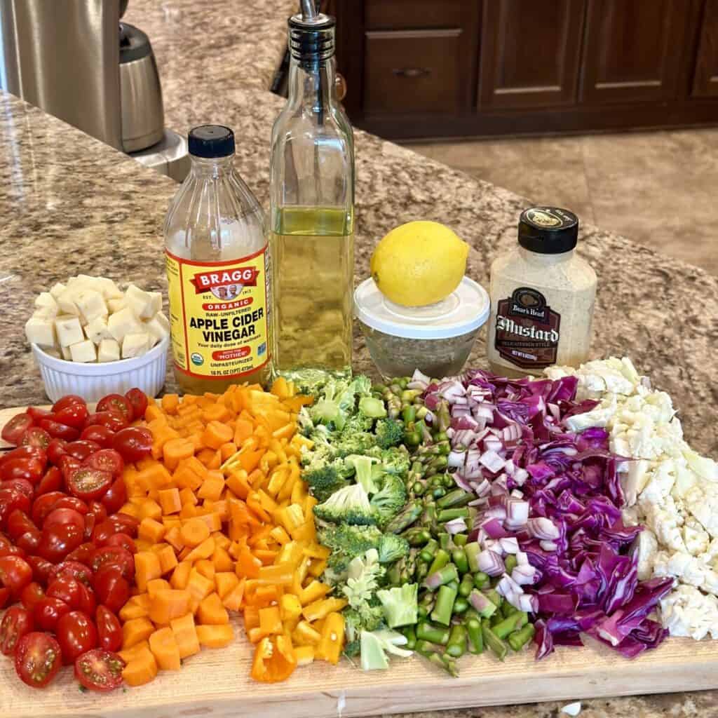 Chopped veggies on a board and the ingredients to make a dressing behind them.