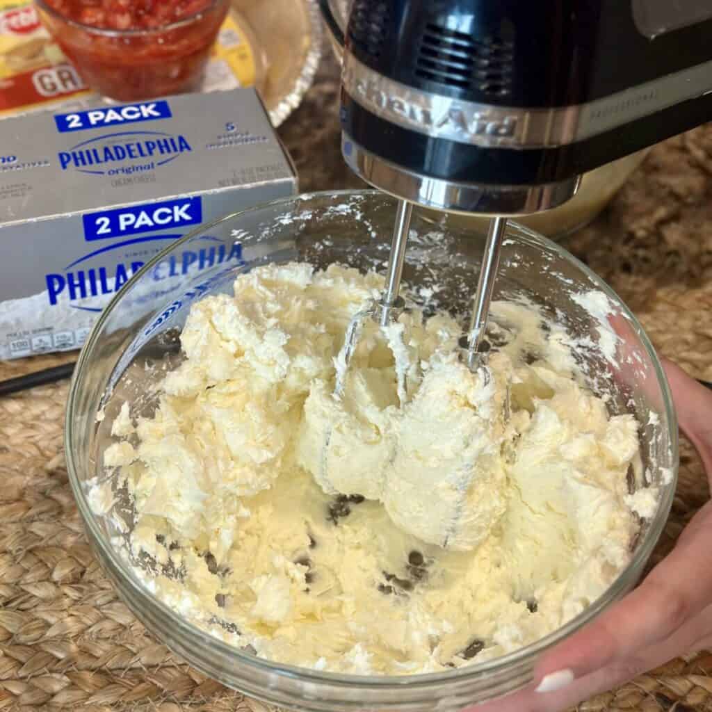 Beating cream cheese in a bowl.