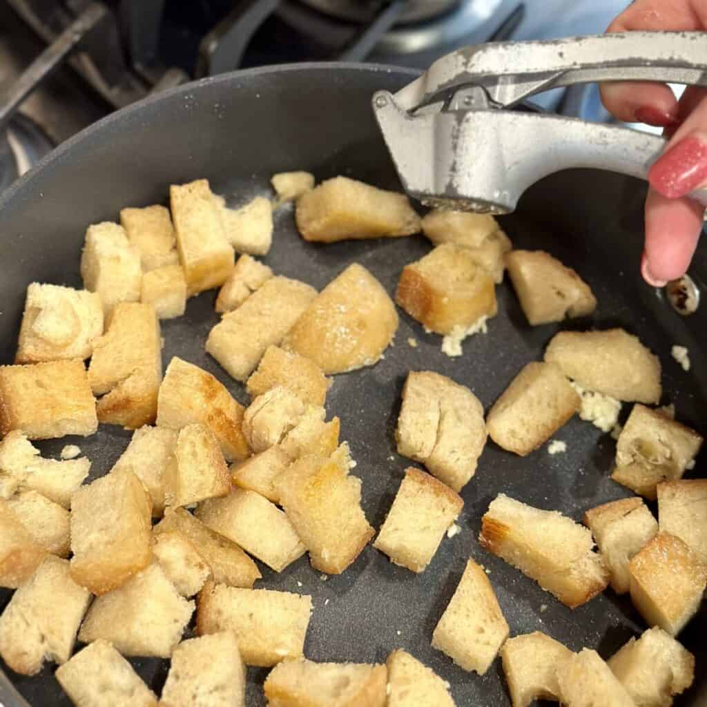 A skillet of toasted cubes of bread.