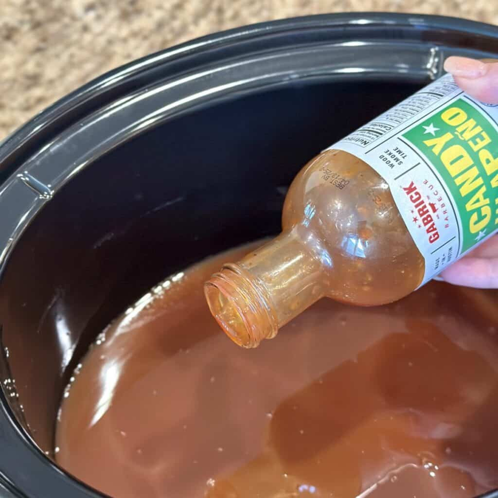 Adding bbq sauce to a crockpot.