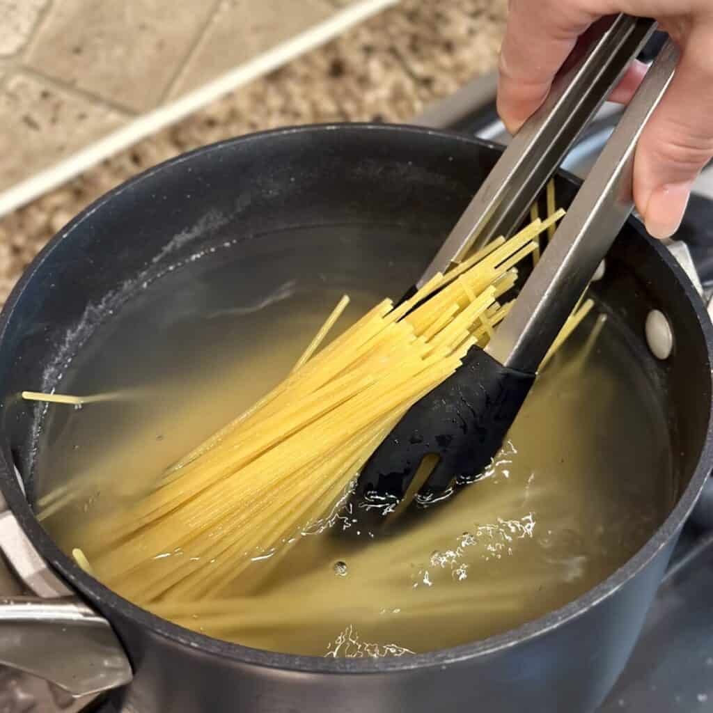 Cooking spaghetti in a pot.