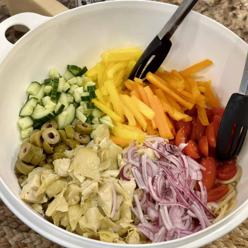 Pasta and veggies in a bowl ready to be mixed.