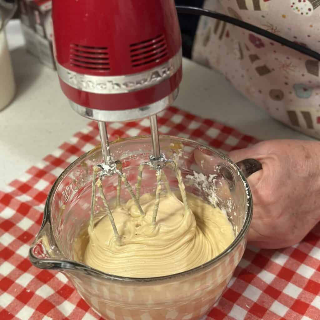 Mixing together peanut butter and cream cheese in a bowl.