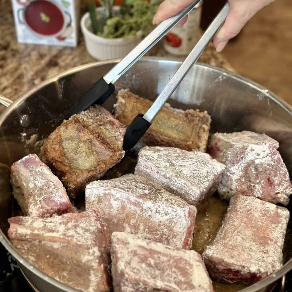 Searing short ribs in a pan.