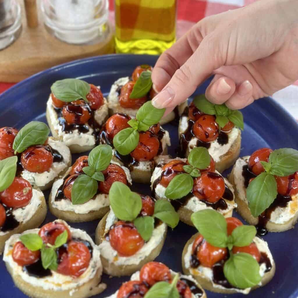 A plate of ricotta bruschetta with roasted tomatoes.