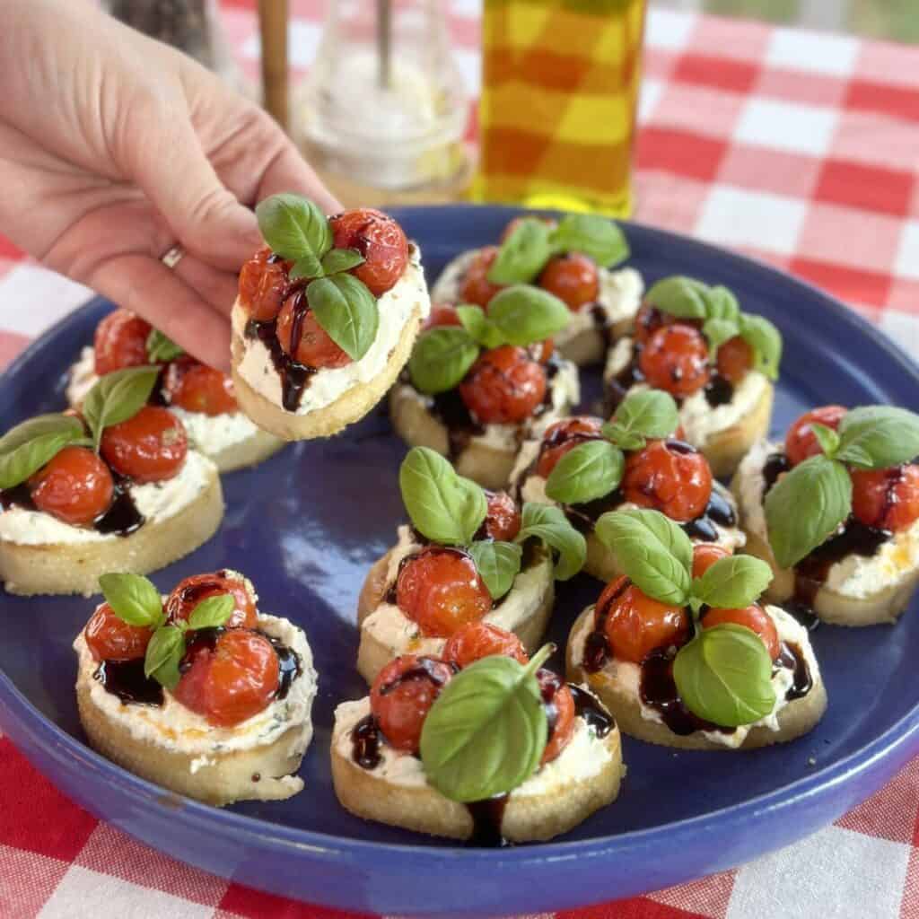 A plate of ricotta bruschetta with roasted tomatoes.