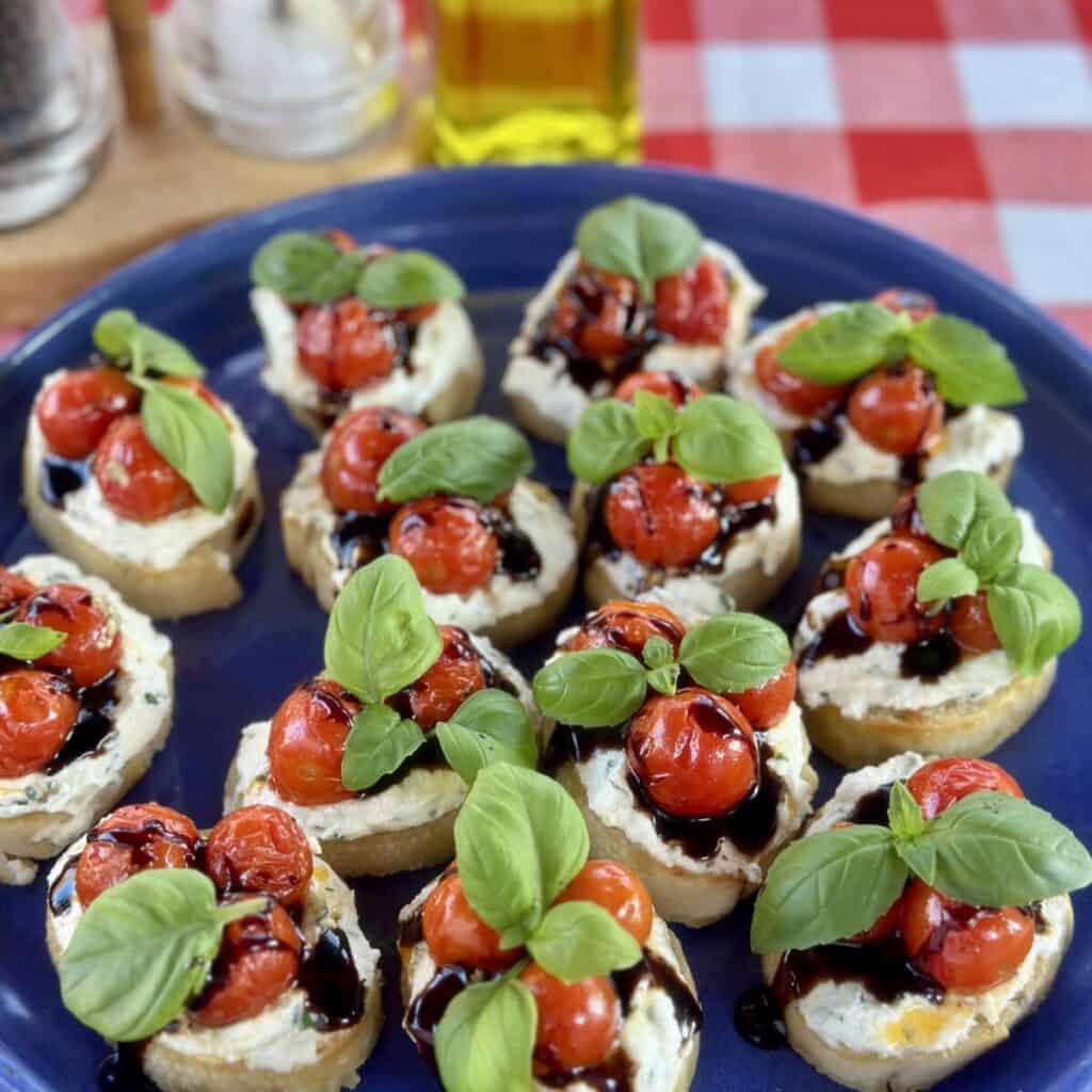 A plate of ricotta bruschetta with roasted tomatoes.