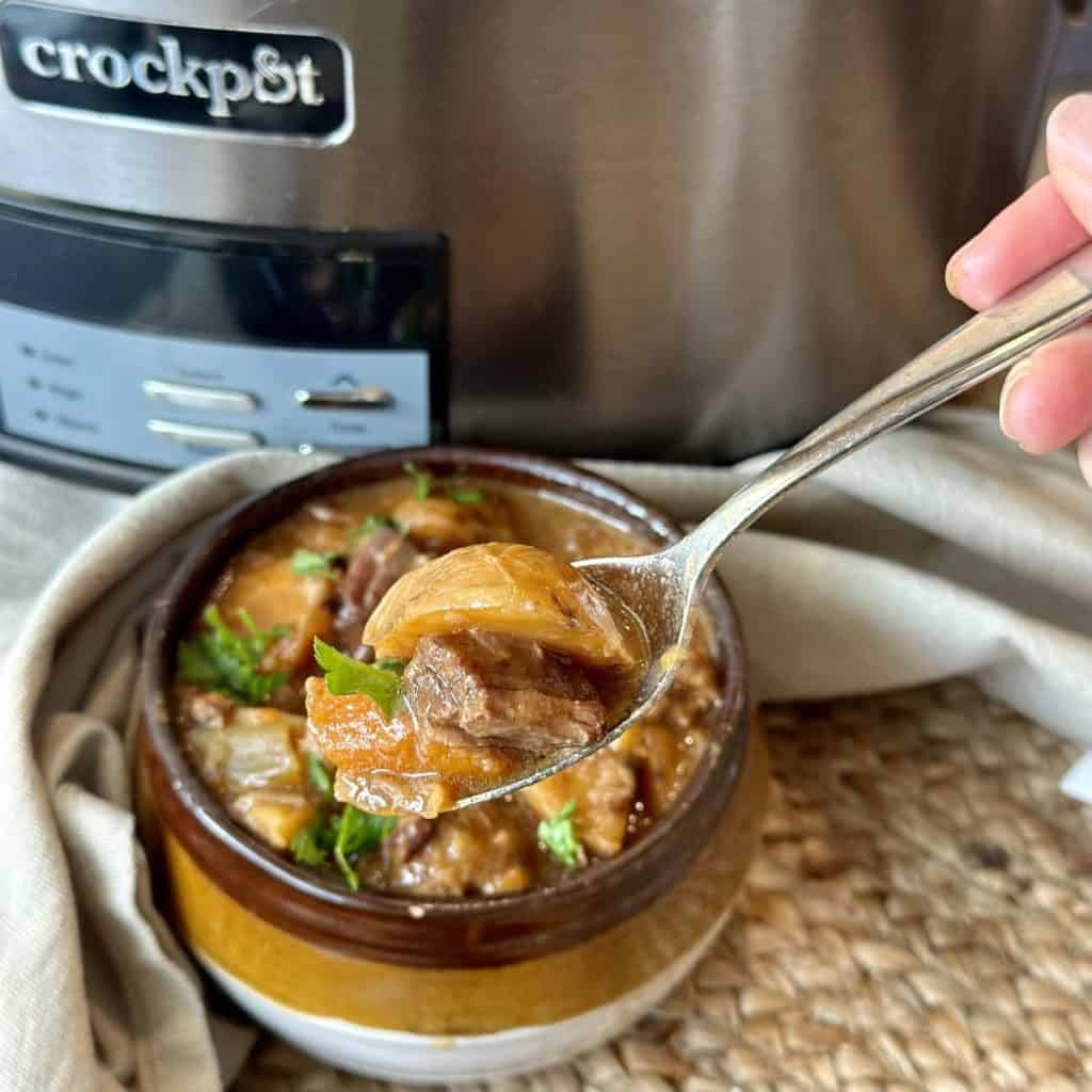 A bite of beef stew on a spoon.