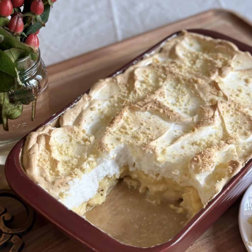 A baked banana pudding  with a slice removed . 