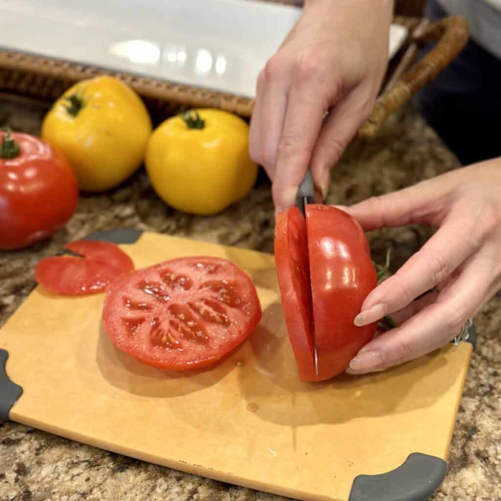 Cutting tomatoes into ¼ inch slices.
