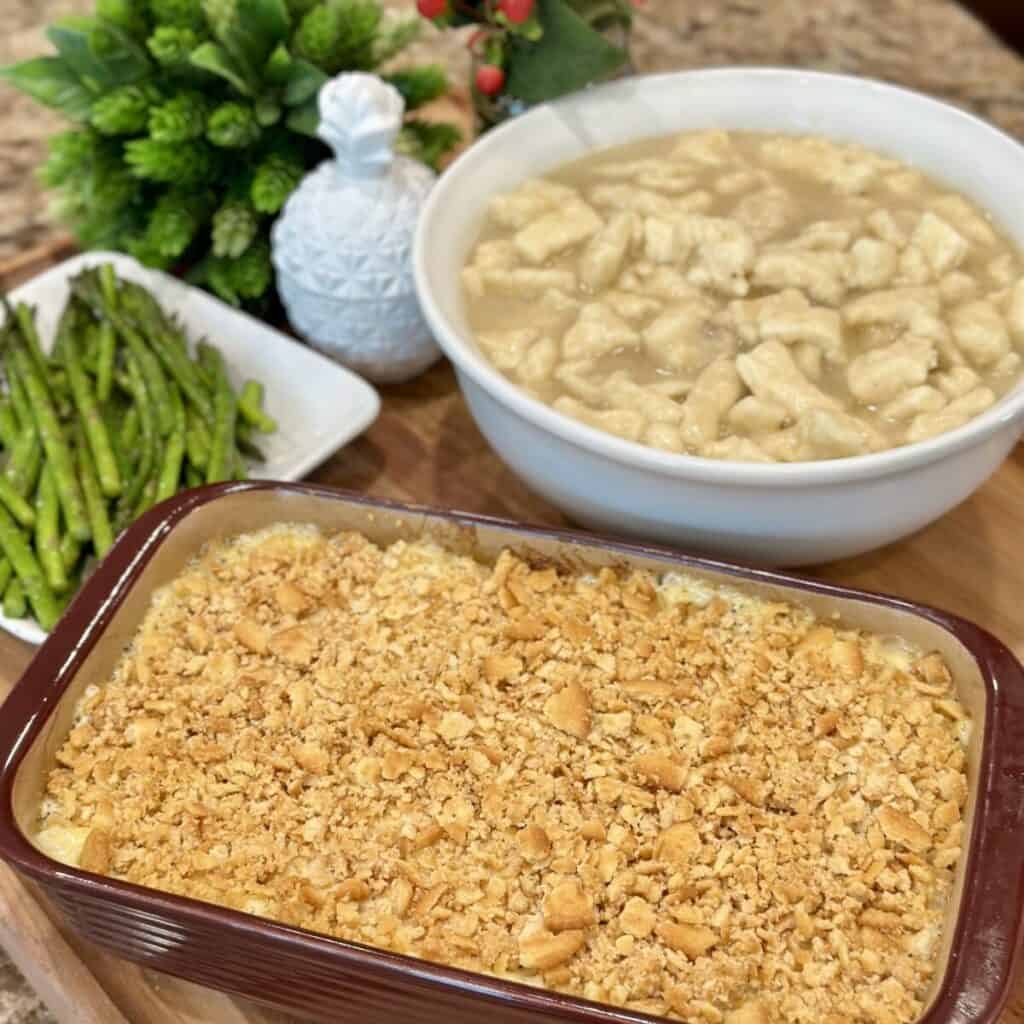 A chicken poppyseed casserole, dumplings, and asparagus ready to be served.