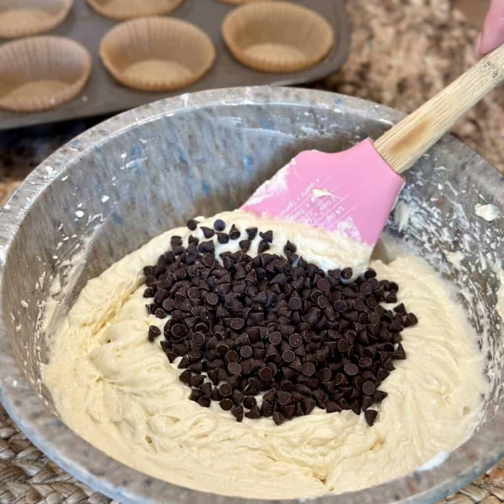 Folding chocolate chips in cupcake batter.
