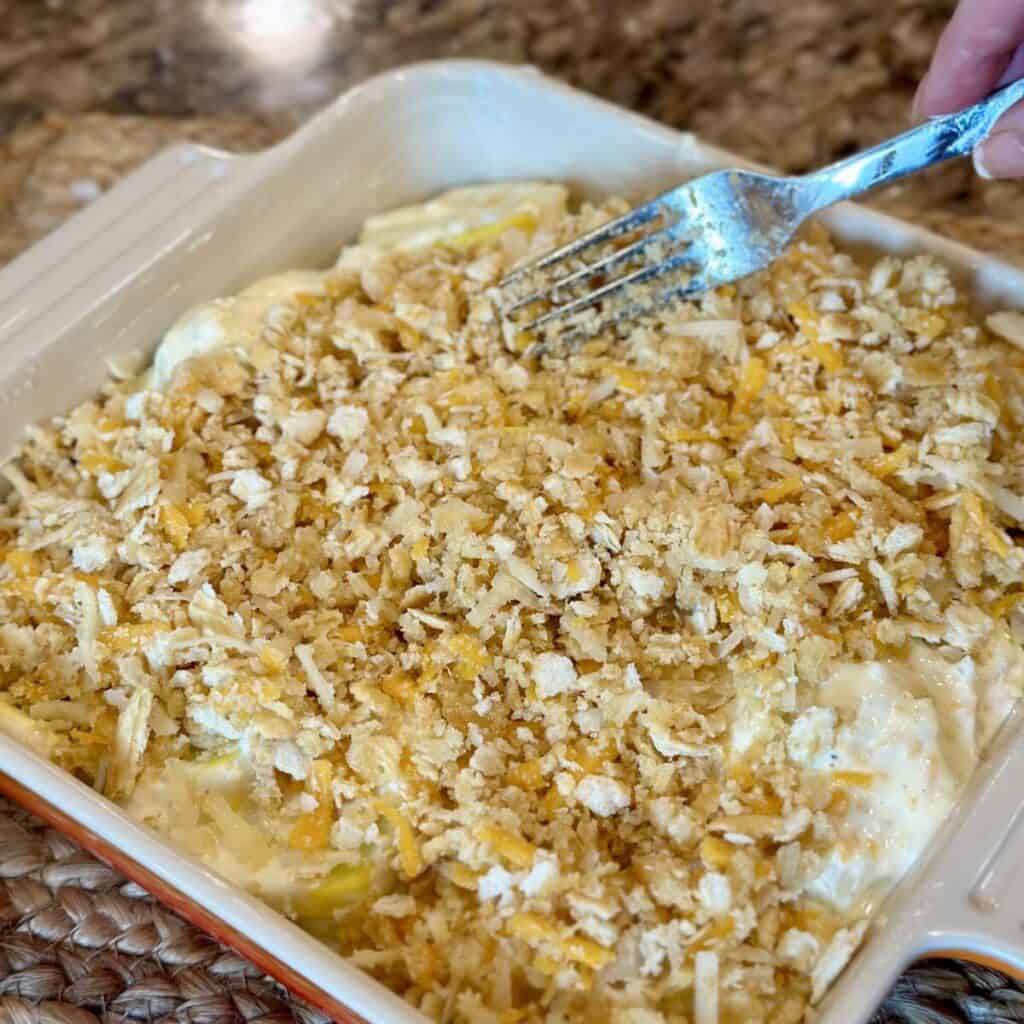 Adding a cracker crumb topping to a casserole.