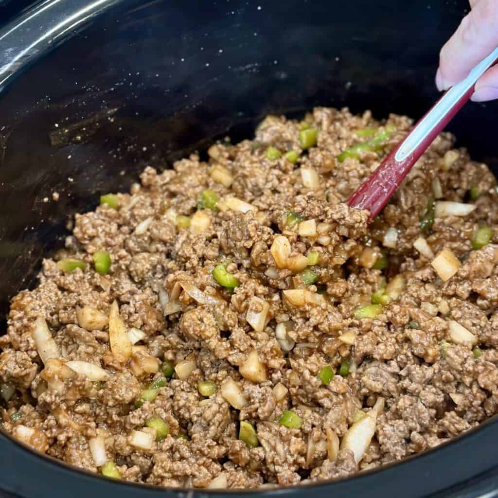 Combining the ingredients for slow cooker sloppy joes in a crockpot.