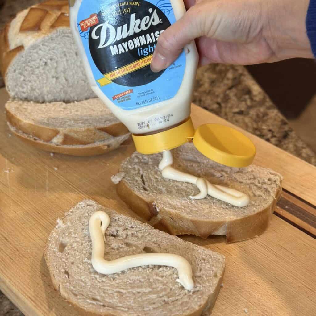 Spreading mayonnaise on bread.