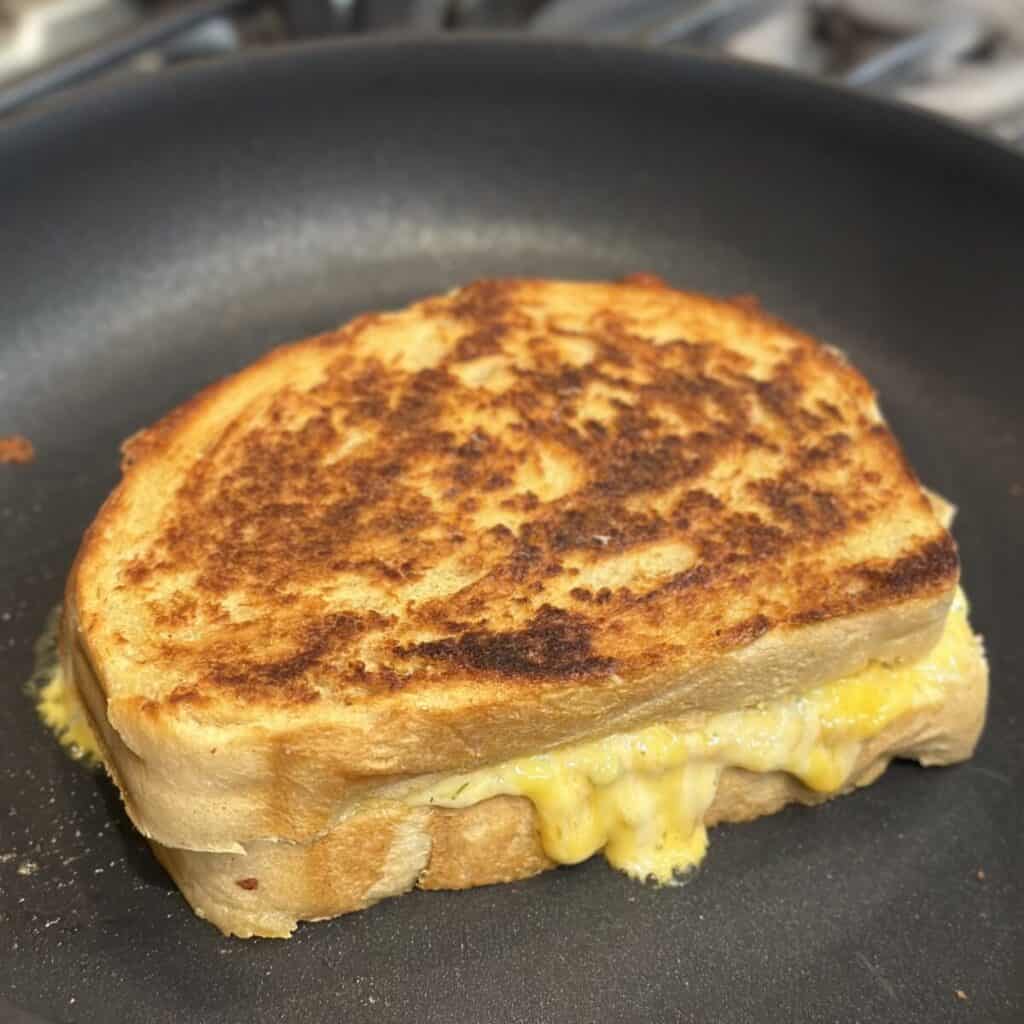 A grilled pimento cheese cooking in a pan.