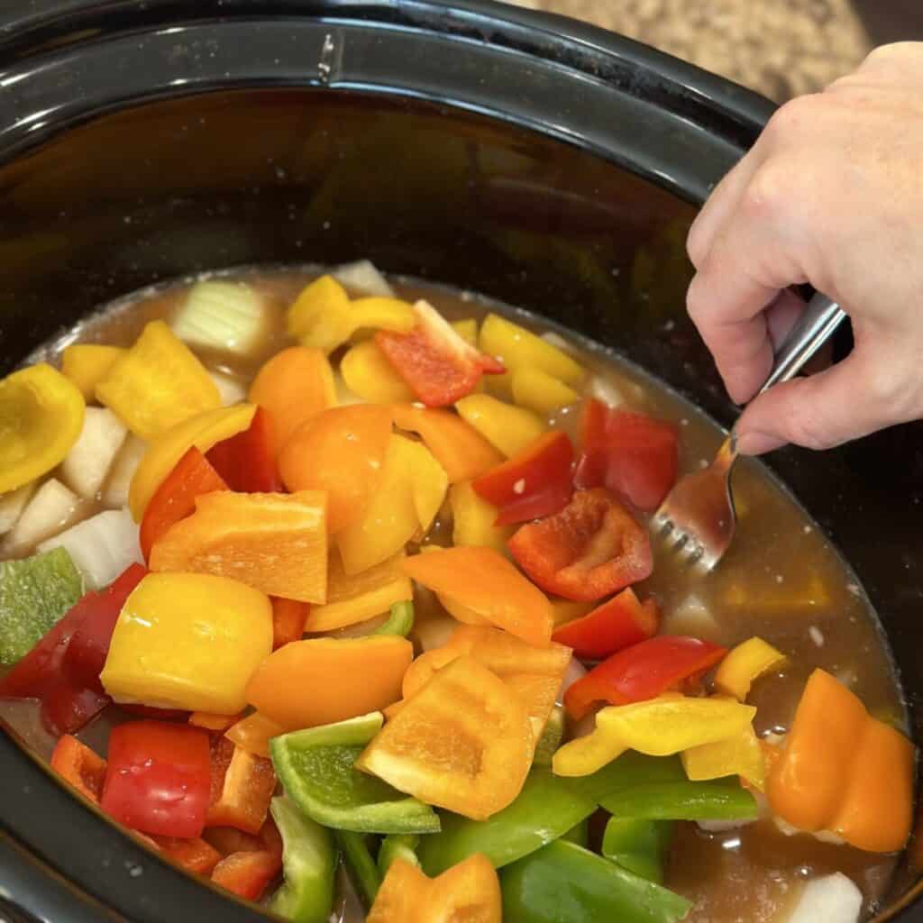 Adding bell peppers to the top of flank steak.