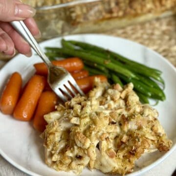 A plate of chicken and swiss casserole with carrots and green beans.