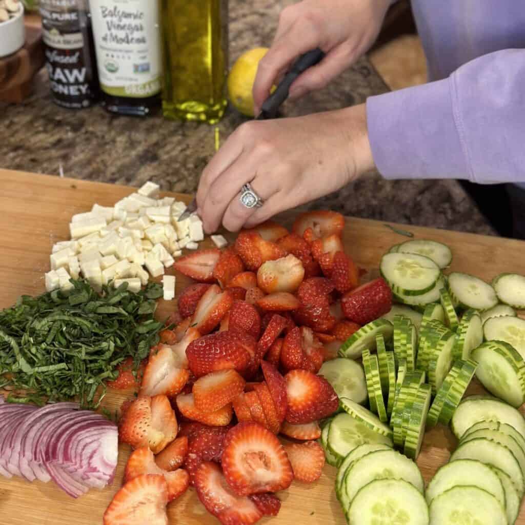 Slicing feta cheese on a cutting board.