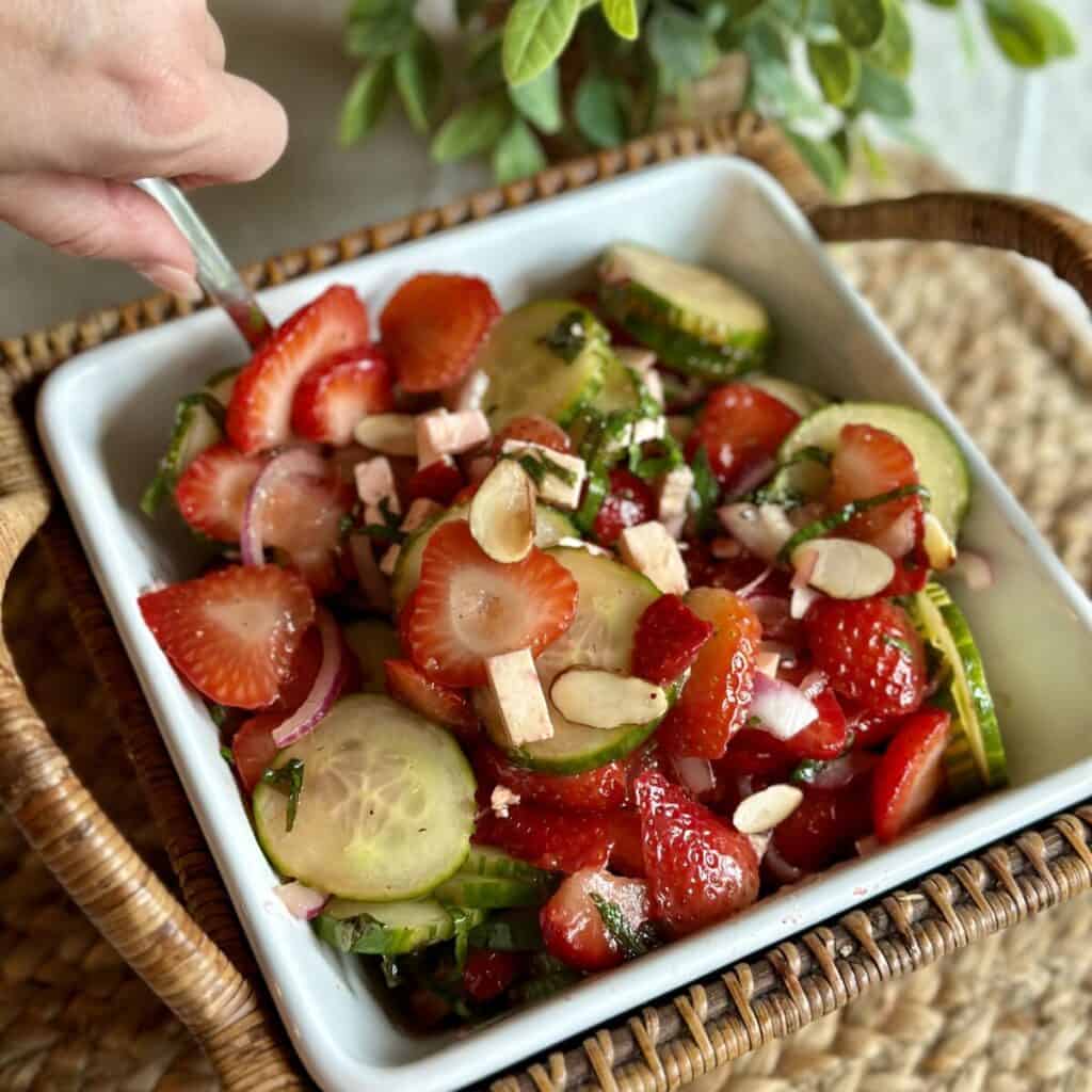 Scooping out a serving of cucumber and strawberry salad.