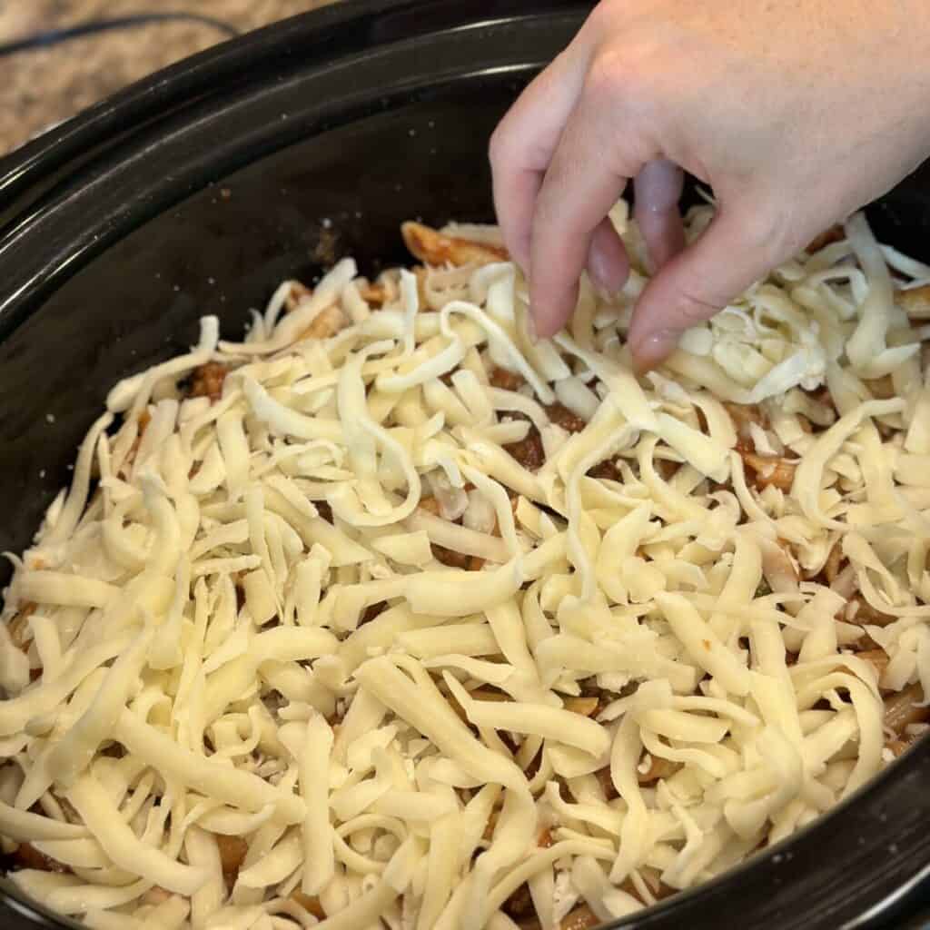 Layering cheese in a crockpot.