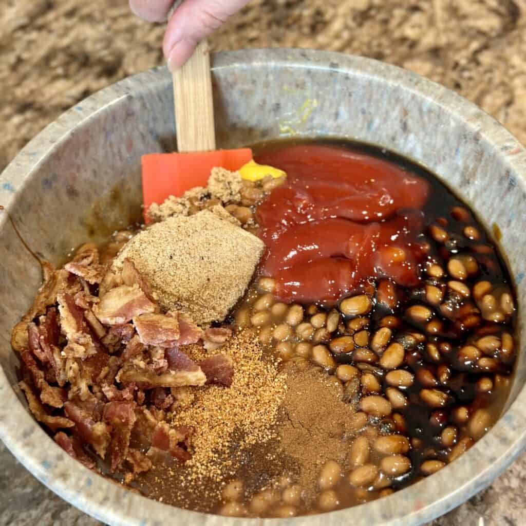 Mixing together ingredients in a bowl for baked beans.
