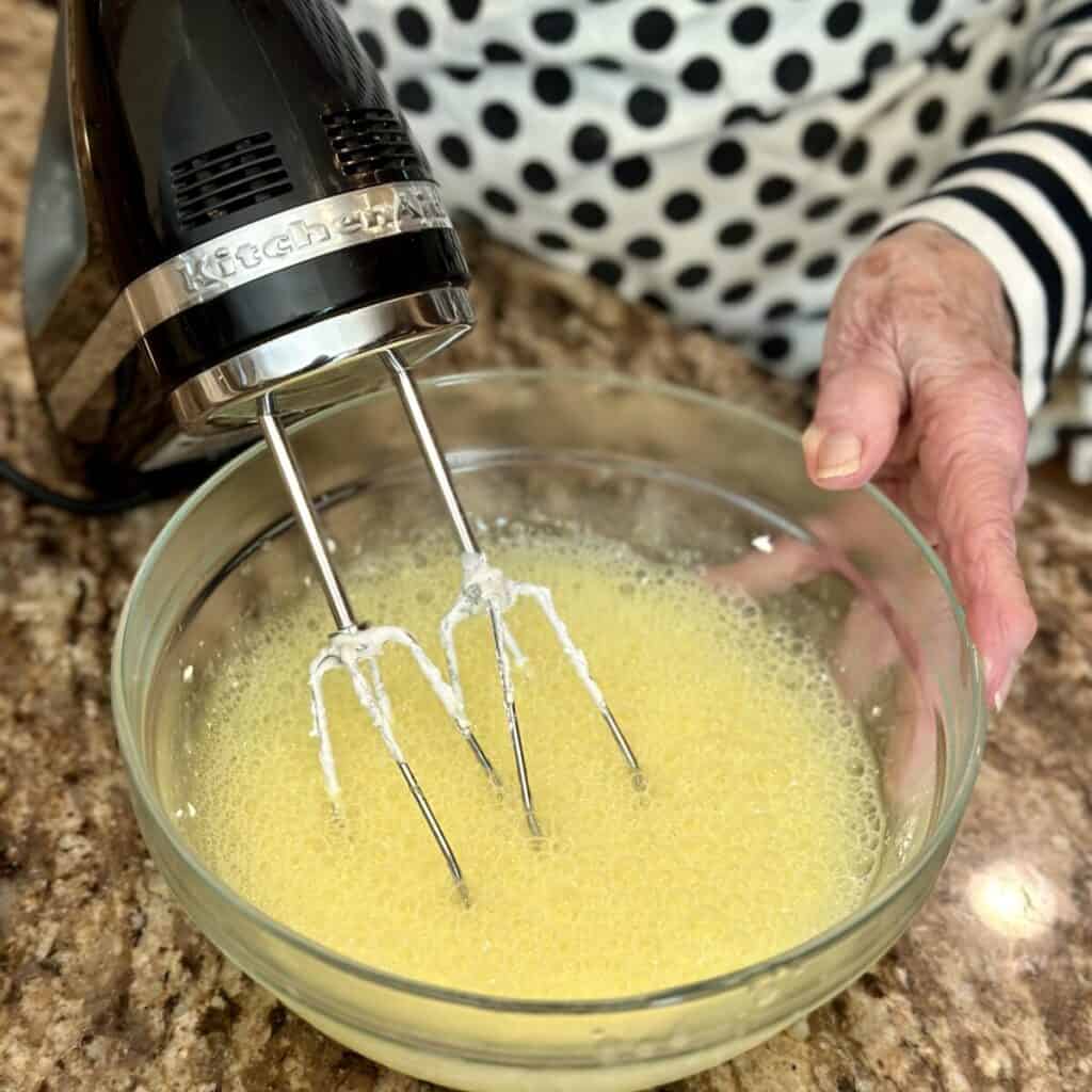 Mixing lemon jello and water.