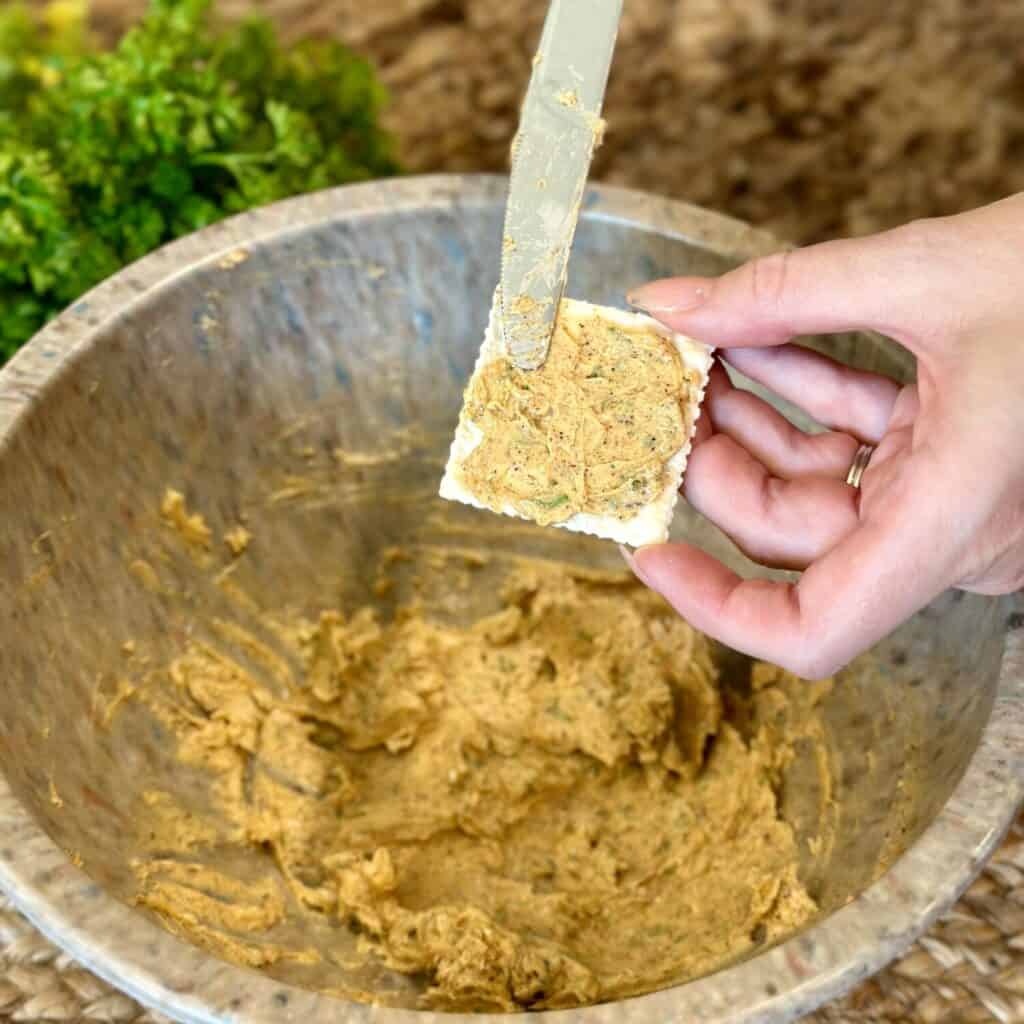 Spreading cajun butter on a cracker.