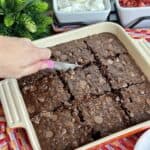 Slicing Baked chocolate oatmeal with berries and cream.