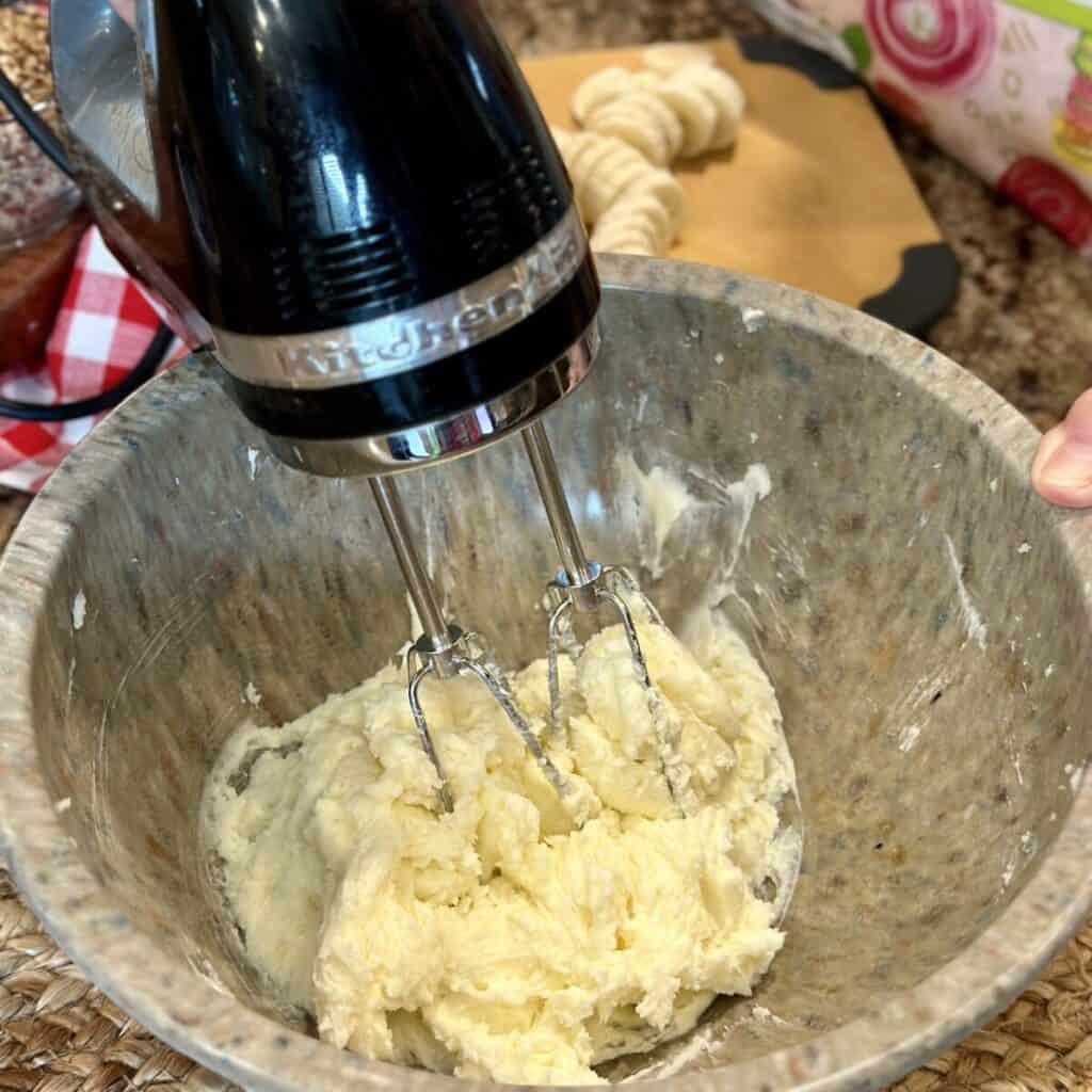 Blending together cream cheese and sugar.