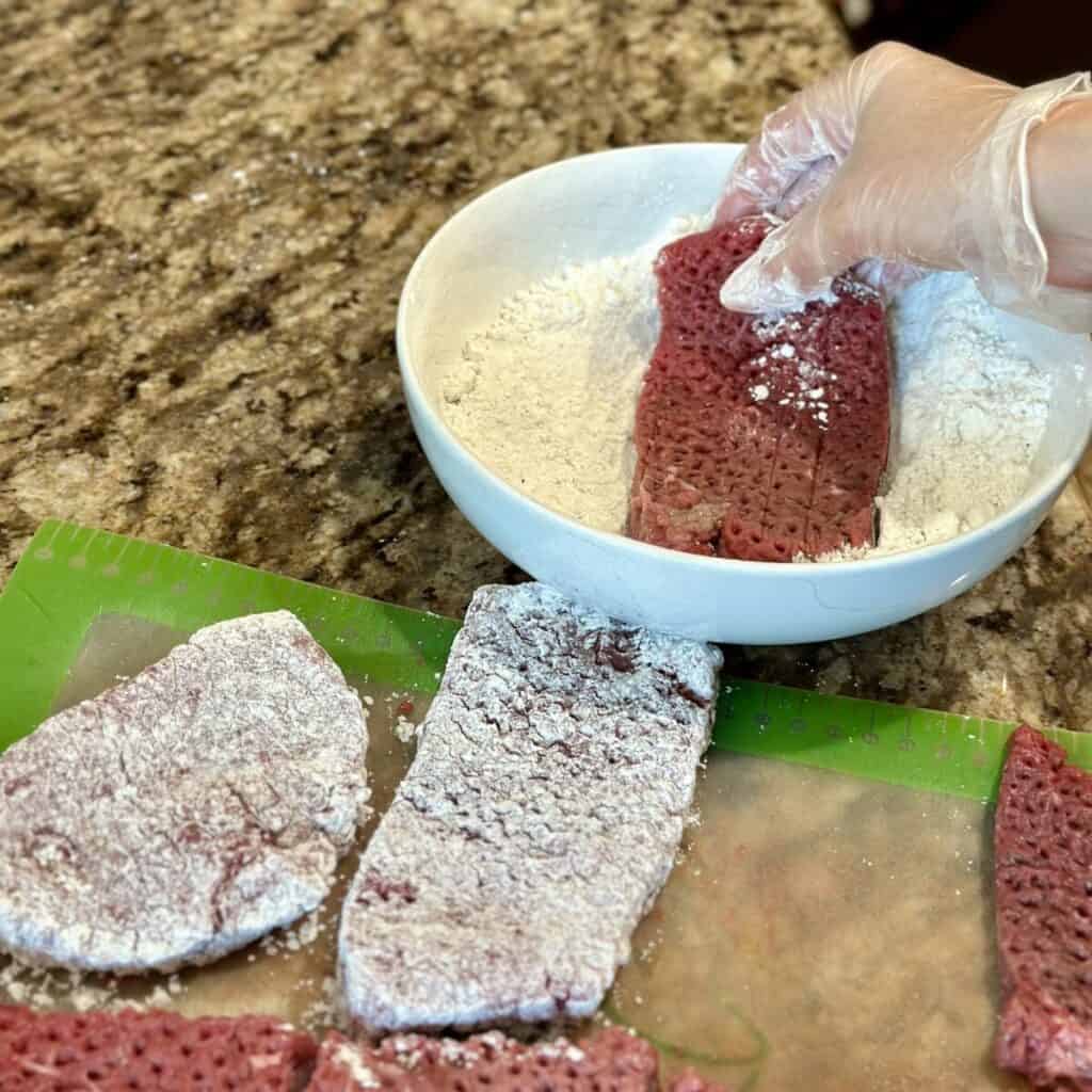 Coating steak in flour.