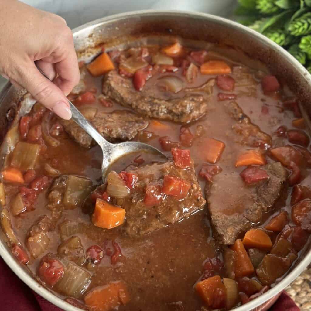 Getting a swiss steak our of a pan of gravy.