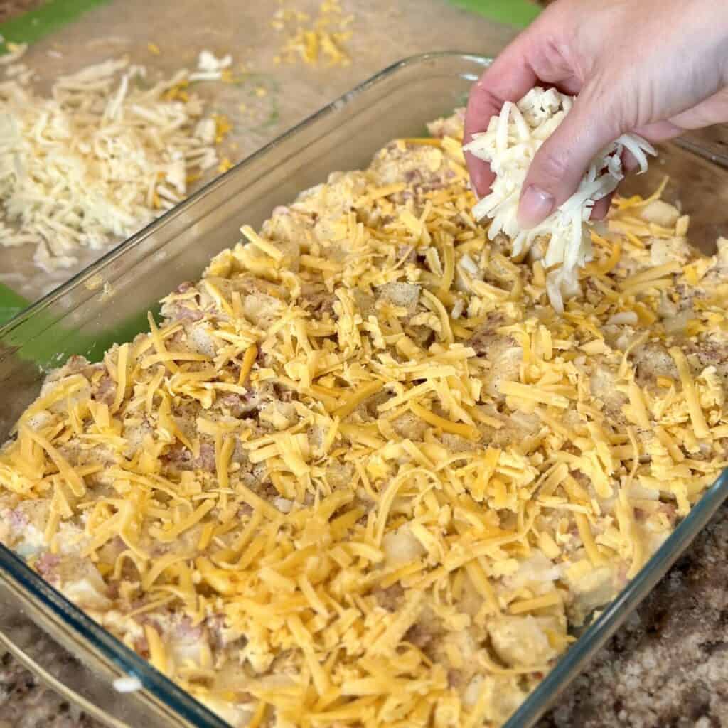 Adding cheese to the top of a casserole.