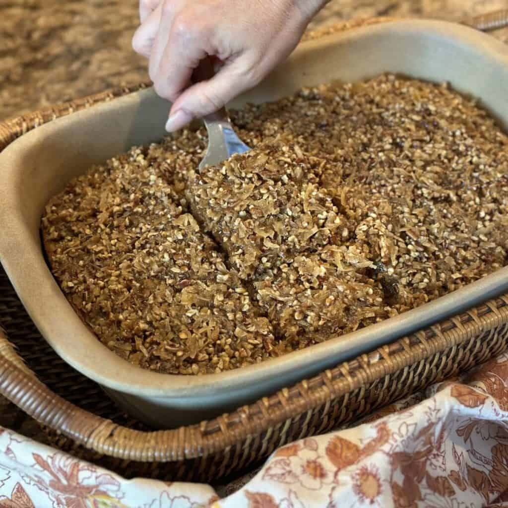 Cutting a slice of oatmeal cake.