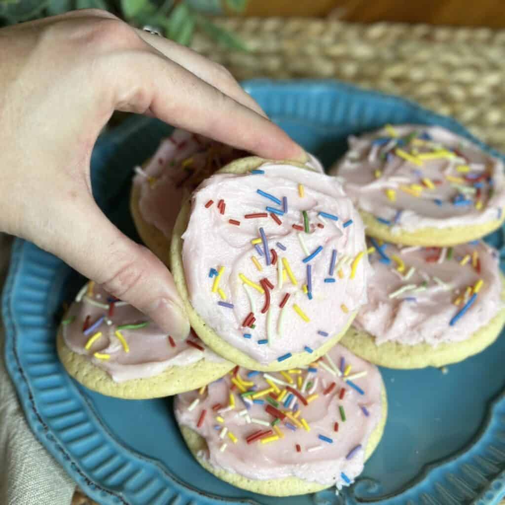 Holding a frosted tea cake cookie.